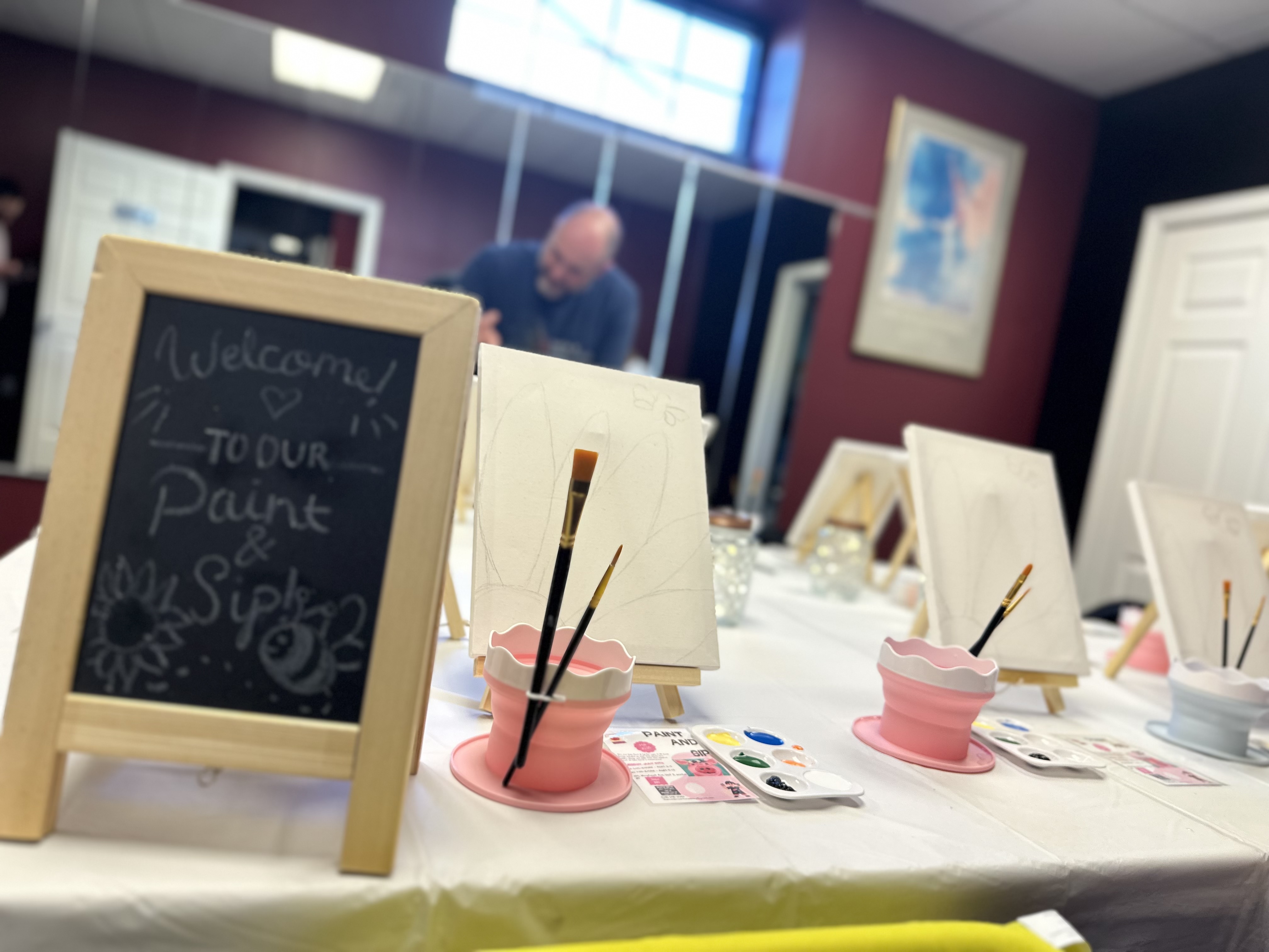 Adults painting and sipping wine